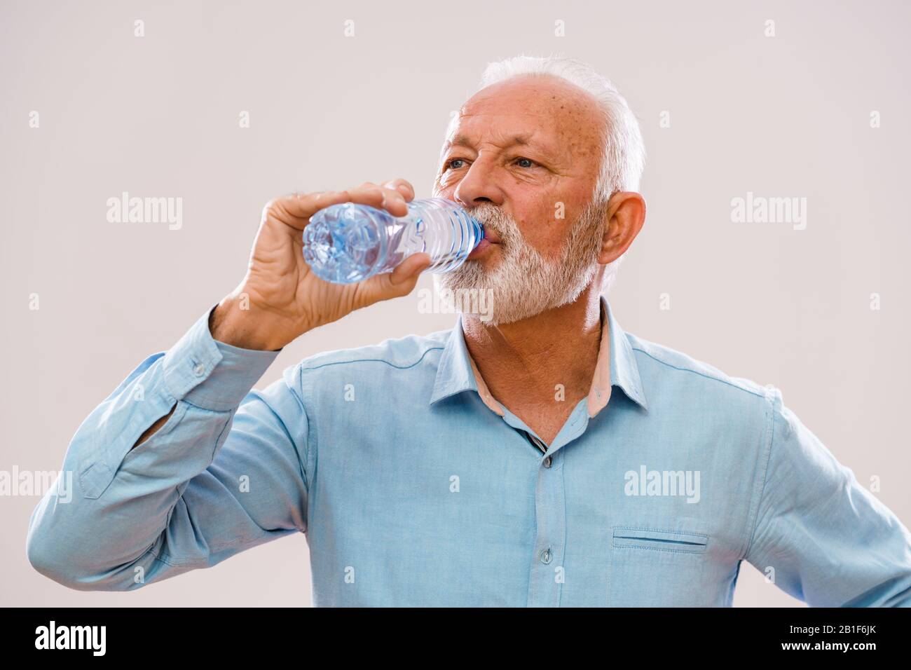Porträt eines älteren Mannes, der Trinkwasser ist. Stockfoto