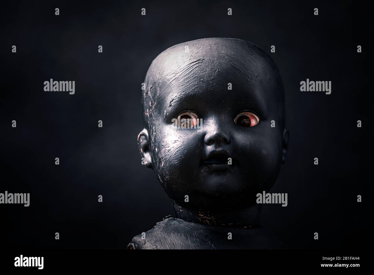 Gruselige Puppe in der Dunkelheit Stockfoto