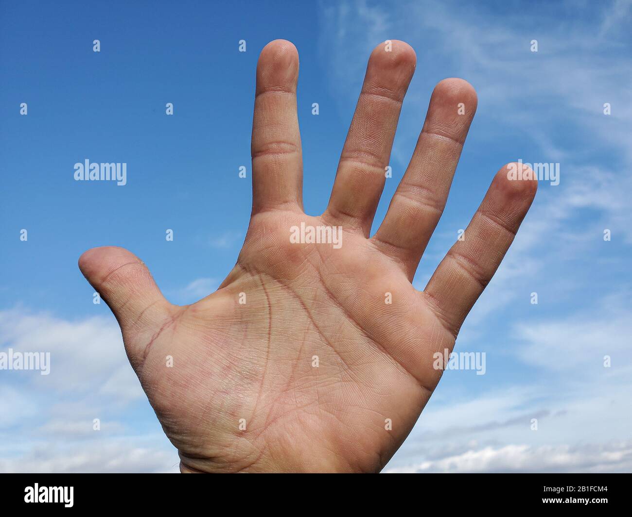 Menschliche Hand über klaren blauen Himmel Hintergrund, Mann Power Konzept, Freiheit Stockfoto