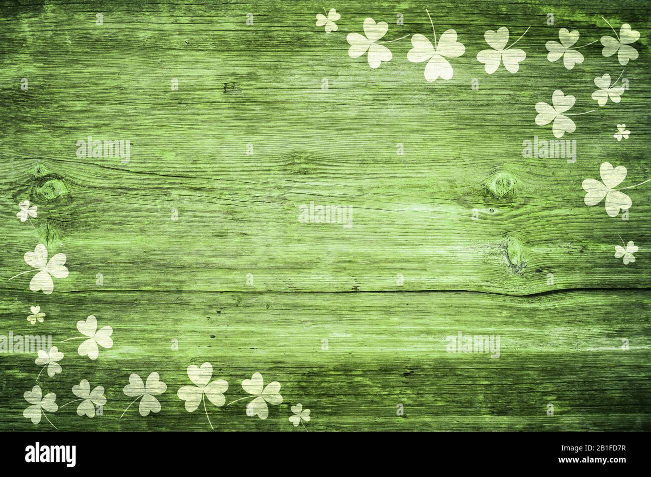 Shamrocks auf grünem Holztisch ein Symbol und St. Patricks Day. Bbanner mit Eckrand von Shamrocks. Strukturiertes Muster Stockfoto