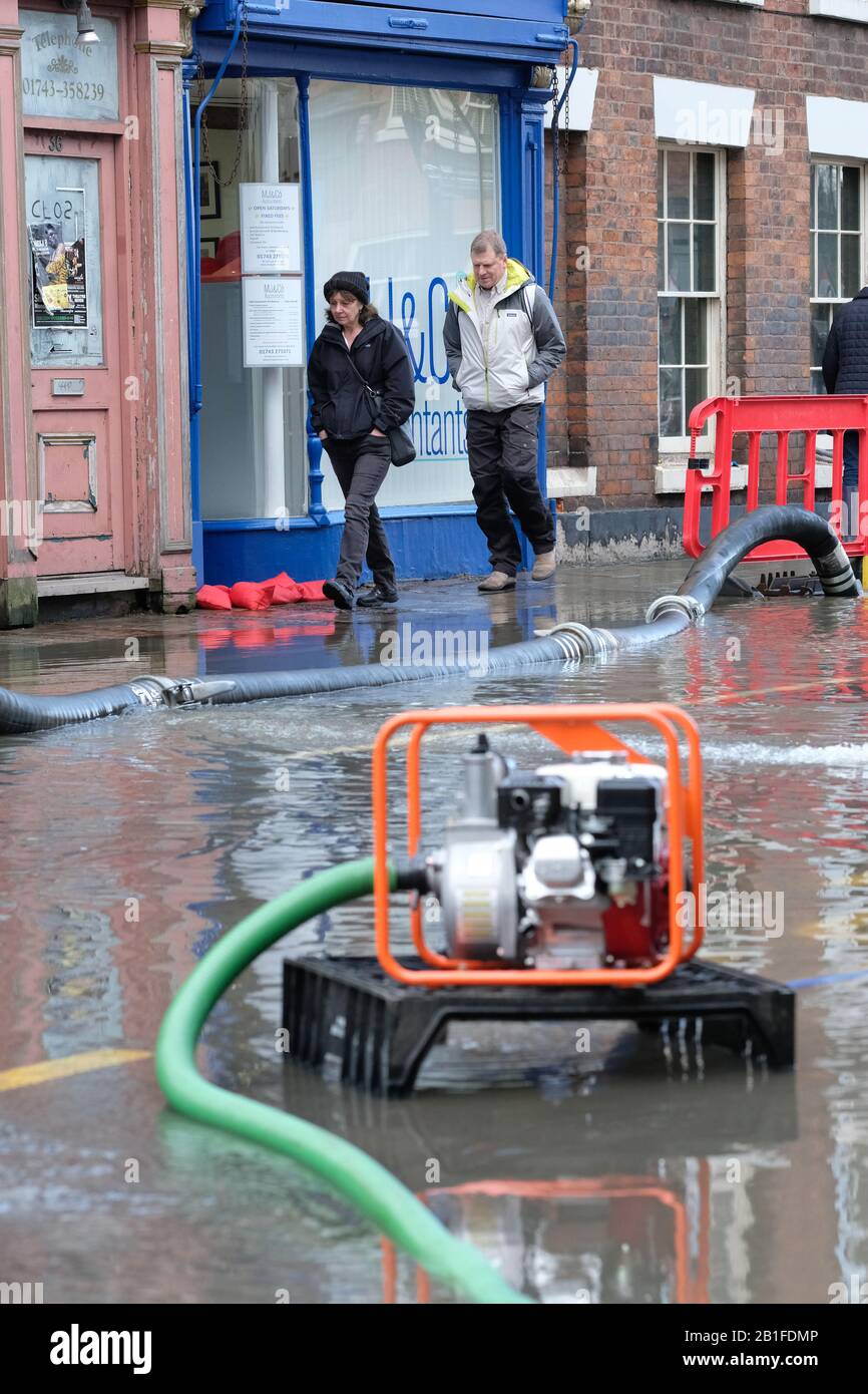 Shrewsbury, Shropshire, Großbritannien - Dienstag, 25. Februar 2020 - Käufer bewegen sich in der Innenstadt um Überschwemmungen, Pumpen und Rohre. Der Fluss Severn wird später heute seinen Höhepunkt erreichen, und für Shrewsbury gilt derzeit eine "Severn Flood Warning". Foto Steven May / Alamy Live News Stockfoto