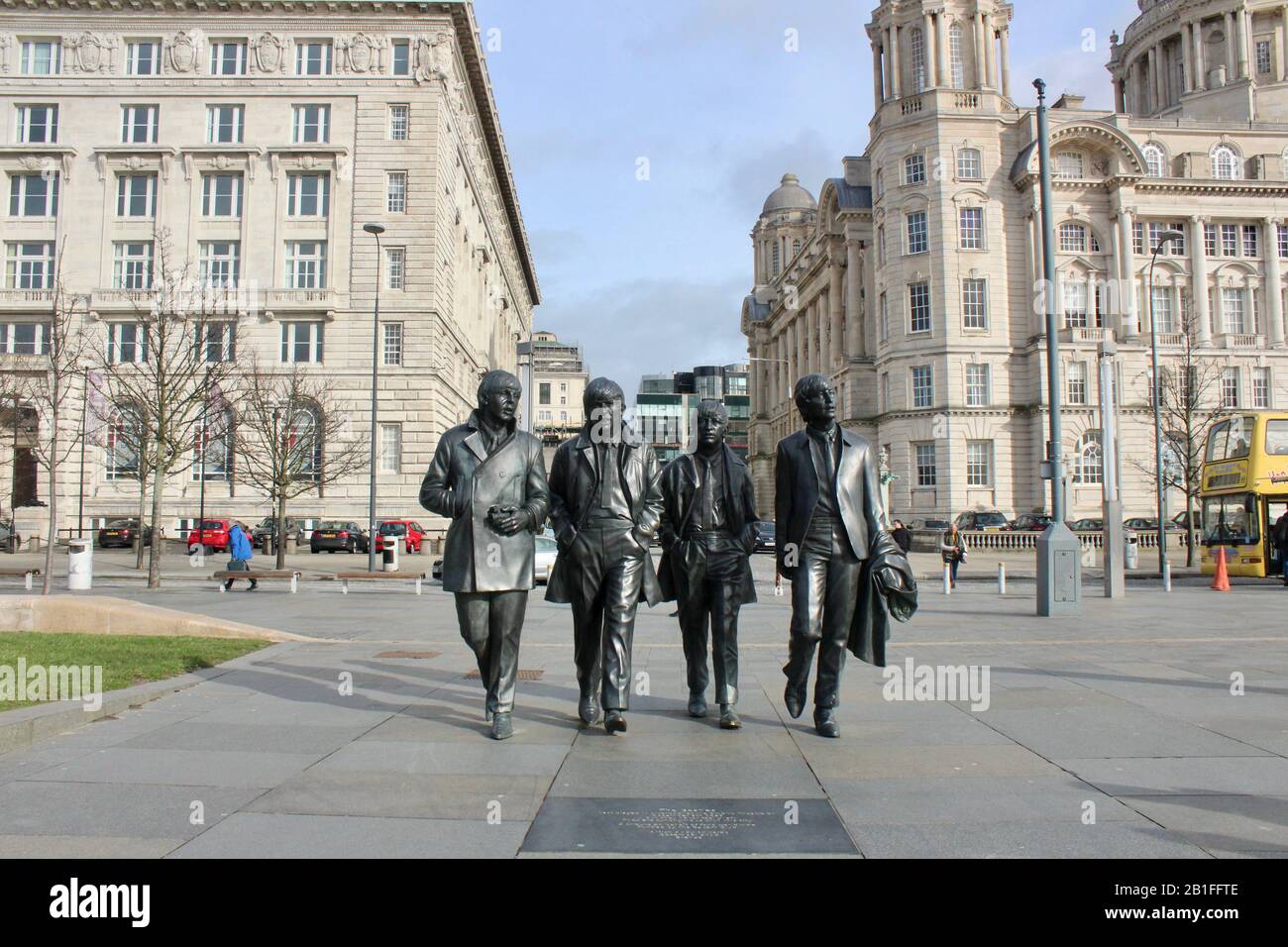 Touristen posieren mit einer Bronzestatue der beatles neben dem mersey in liverpool england UK Stockfoto