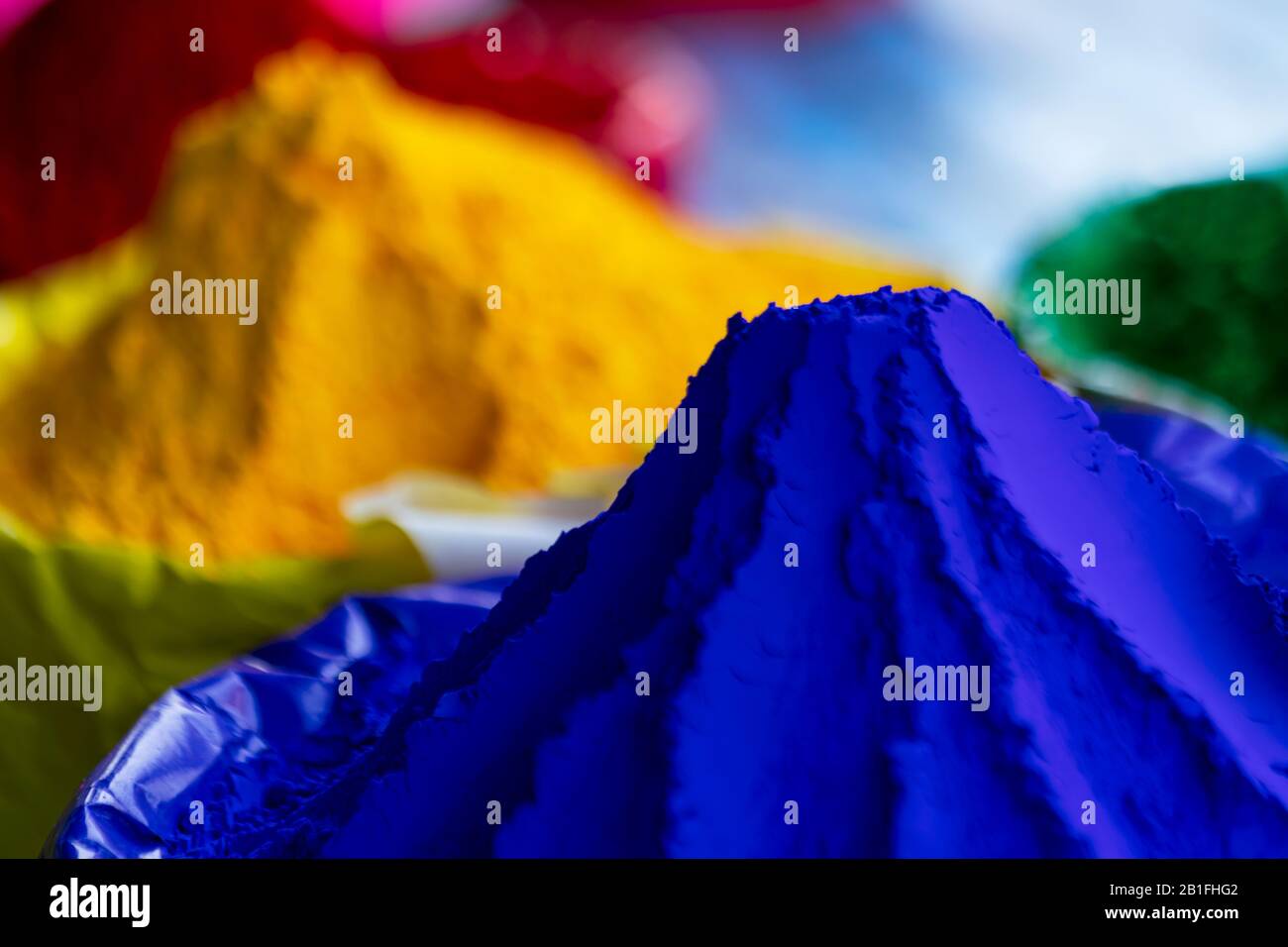 Tasche voller blauer, gelber Farben für das indische Holi Festival. Farbenfroher Schluck für Fröhlichen Holi-Hintergrund, Grußkarte, Pamphlet, Angebot, Grafikressource Stockfoto