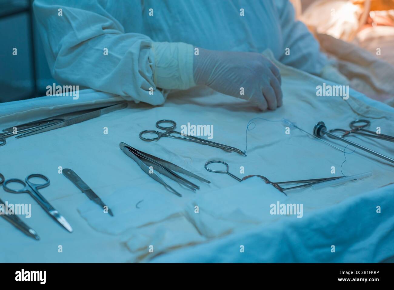 Nahaufnahme, die Hände eines Krankenschwesters Hand, nimmt ein Assistenzchirurg ein chirurgisches Instrument von einem sterilen Tisch. In einem sterilen Operationssaal. MA entfernen Stockfoto