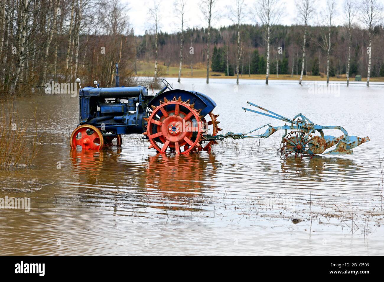 Überschwemmte Traktoren von Vintage Fordson und Pflug in Hämjoki, Flussüberschwemmung durch den Highway 110 in Lohja, Finnland. Februar 2020. Stockfoto