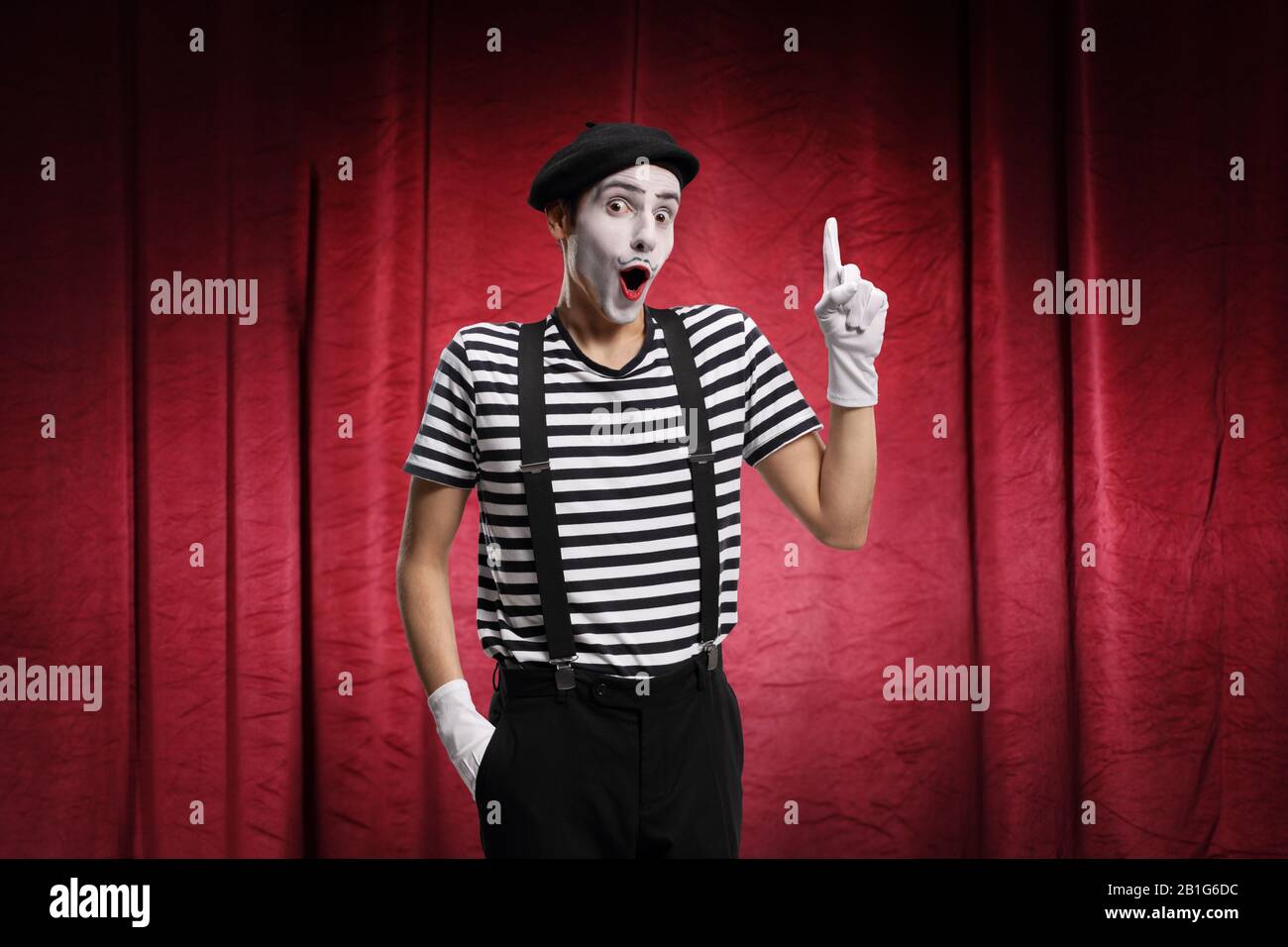 Mann, der Pantomime auf der Bühne mit roten Vorhängen ausführt Stockfoto