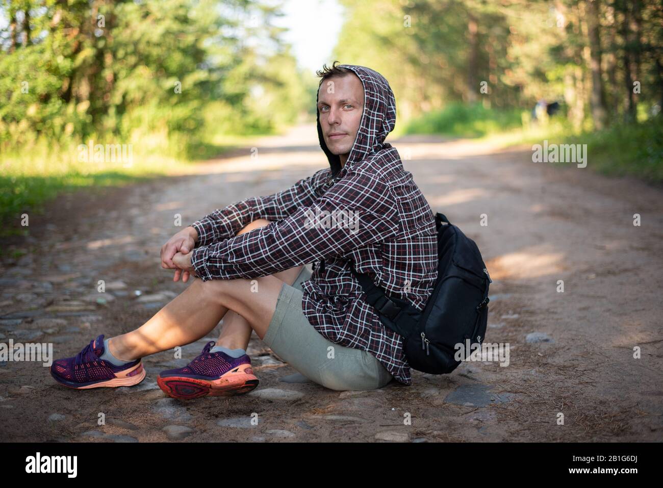 Der Mann sitzt auf der Straße und blickt in den Rahmen. Für jeden Zweck. Stockfoto