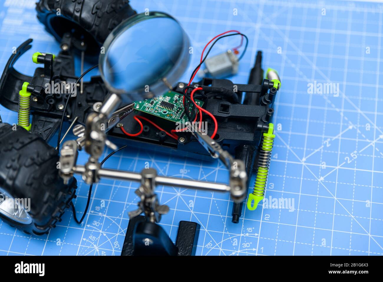Spielzeugauto Assenling mit Leiterplatte. Konzept der Spielzeugelektronik, die für die Ausbildung montiert, repariert, recycelt oder verwendet wird. Stockfoto
