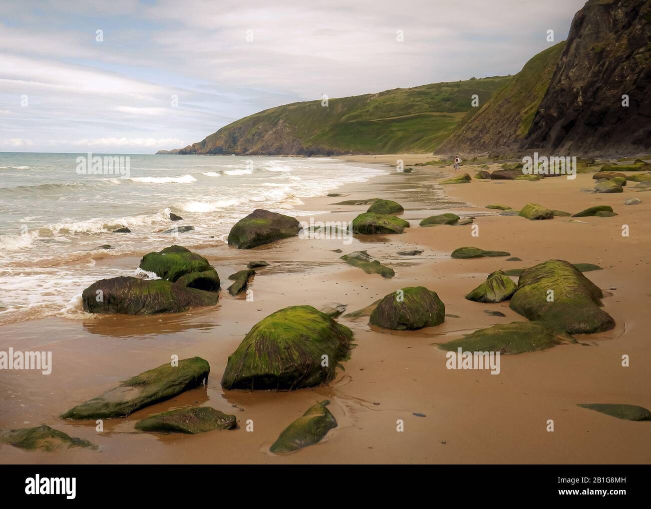 Farbfoto der Küstenfelsen am Strand einige geglättet und abgerundet durch die Passagen von Zeit und Flut mit Steinkobbeln und Kieselsteinen, die auf t liegen Stockfoto