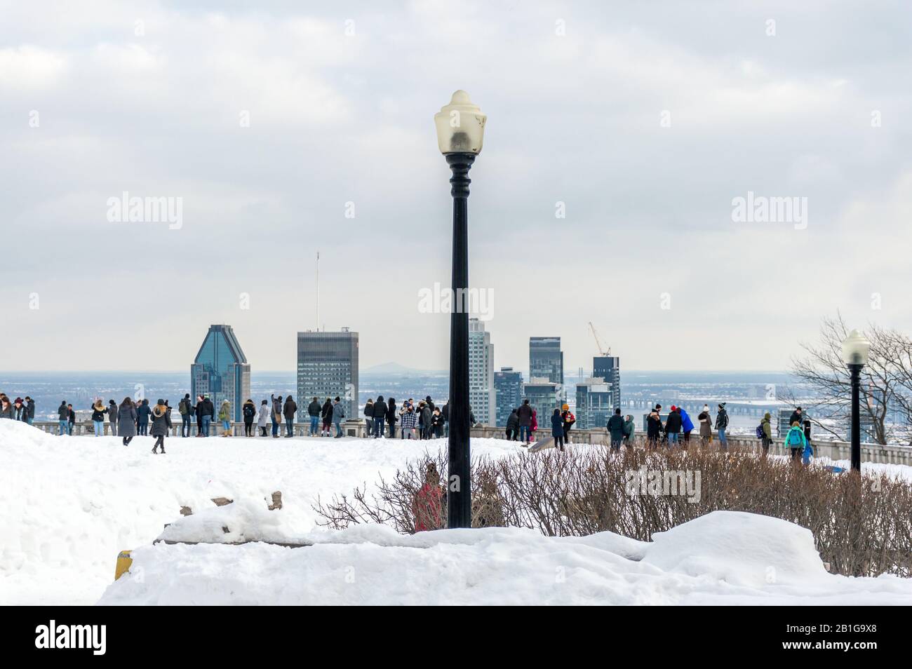 Straßenbeleuchtung und viele Touristen stehen auf Kondiaronk Belvedere, um die Skyline von Montreal zu genießen. Montreal Skyline im Winter, Kanada Stockfoto