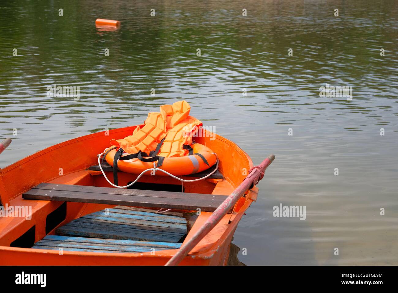 Boot, Rettungsweste, Rettungsschwimmerhülle in orangefarbenem Farbton wichtig für die Sicherheit des Lebens im Wasser im Sommer. Konzeptrettung auf dem Wasser im Sommer. Stockfoto