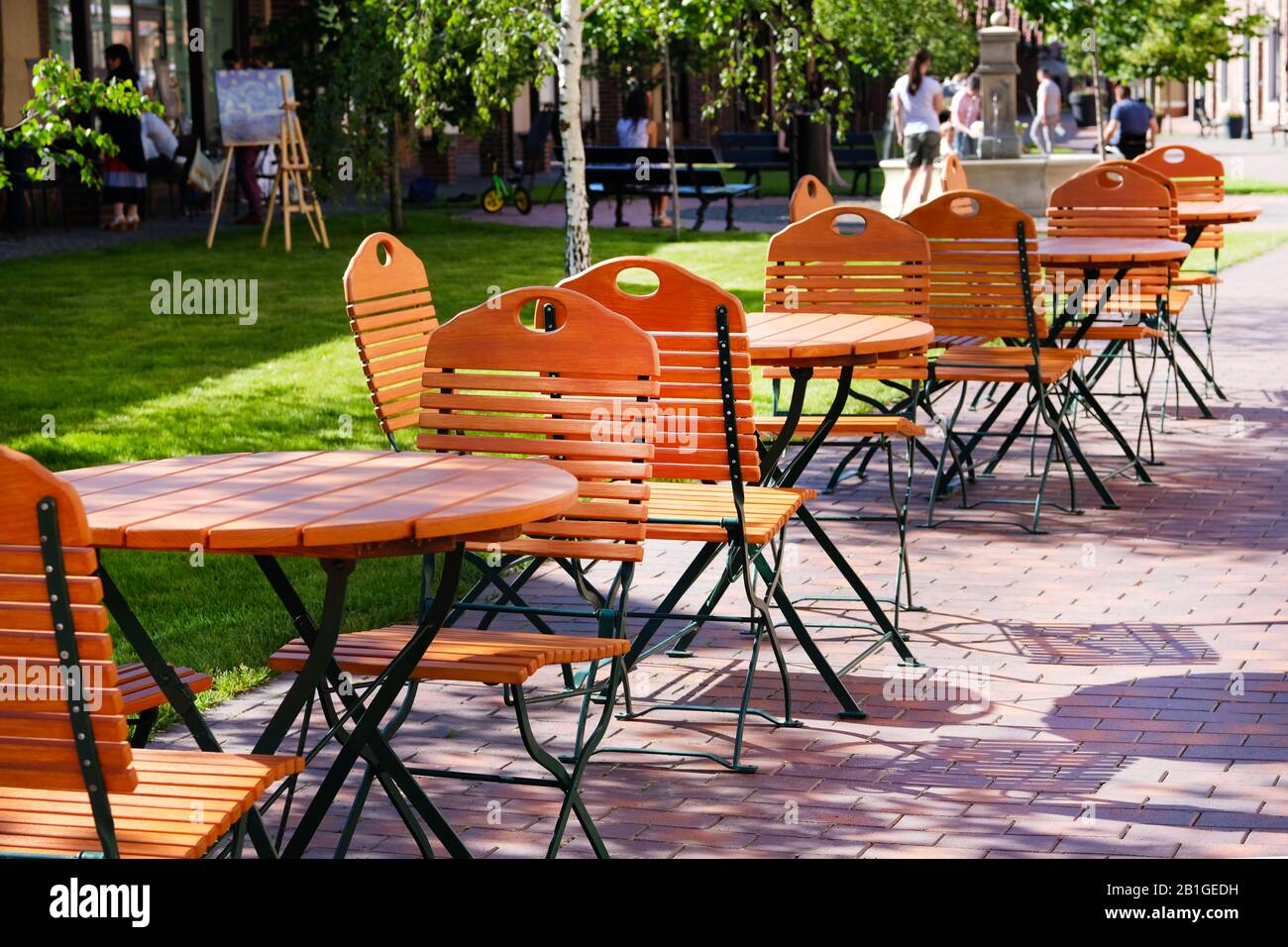 Stühle und Tische im Gartenrestaurant mit Tischbeinen und Stuhlbeinen aus Eisen und Holzplatten Stockfoto