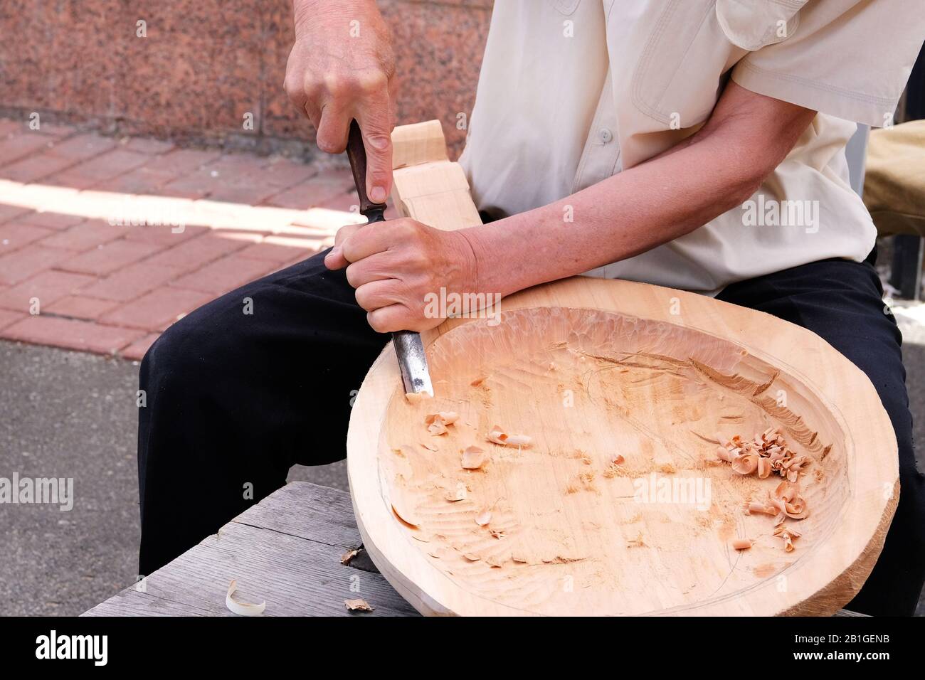Holzschnitzerei. Professioneller Zimmermann schnitzt Holzhandwerk mit einem Holzbearbeitungswerkzeug, Hände nah oben. Zimmerei und Handwerkskunst. Stockfoto