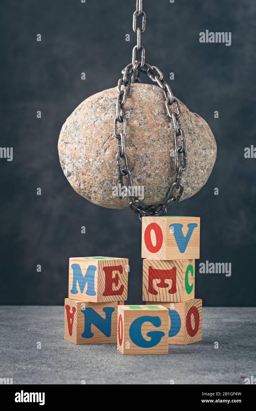 Stein hängt über Buchstabenblöcken Stockfoto