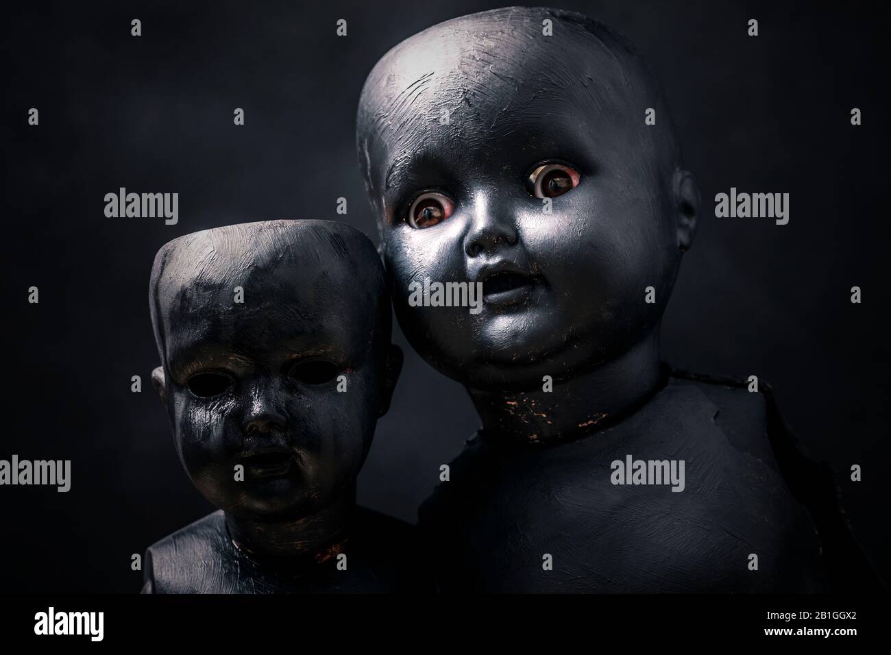 Paar gruselige Puppen in der Dunkelheit Stockfoto