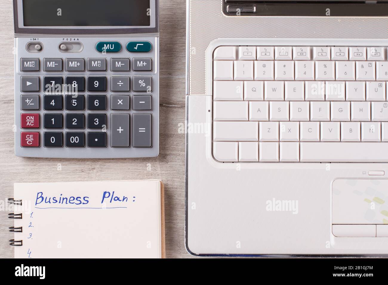 Laptop, Taschenrechner, Notizblock auf dem Tisch. Stockfoto