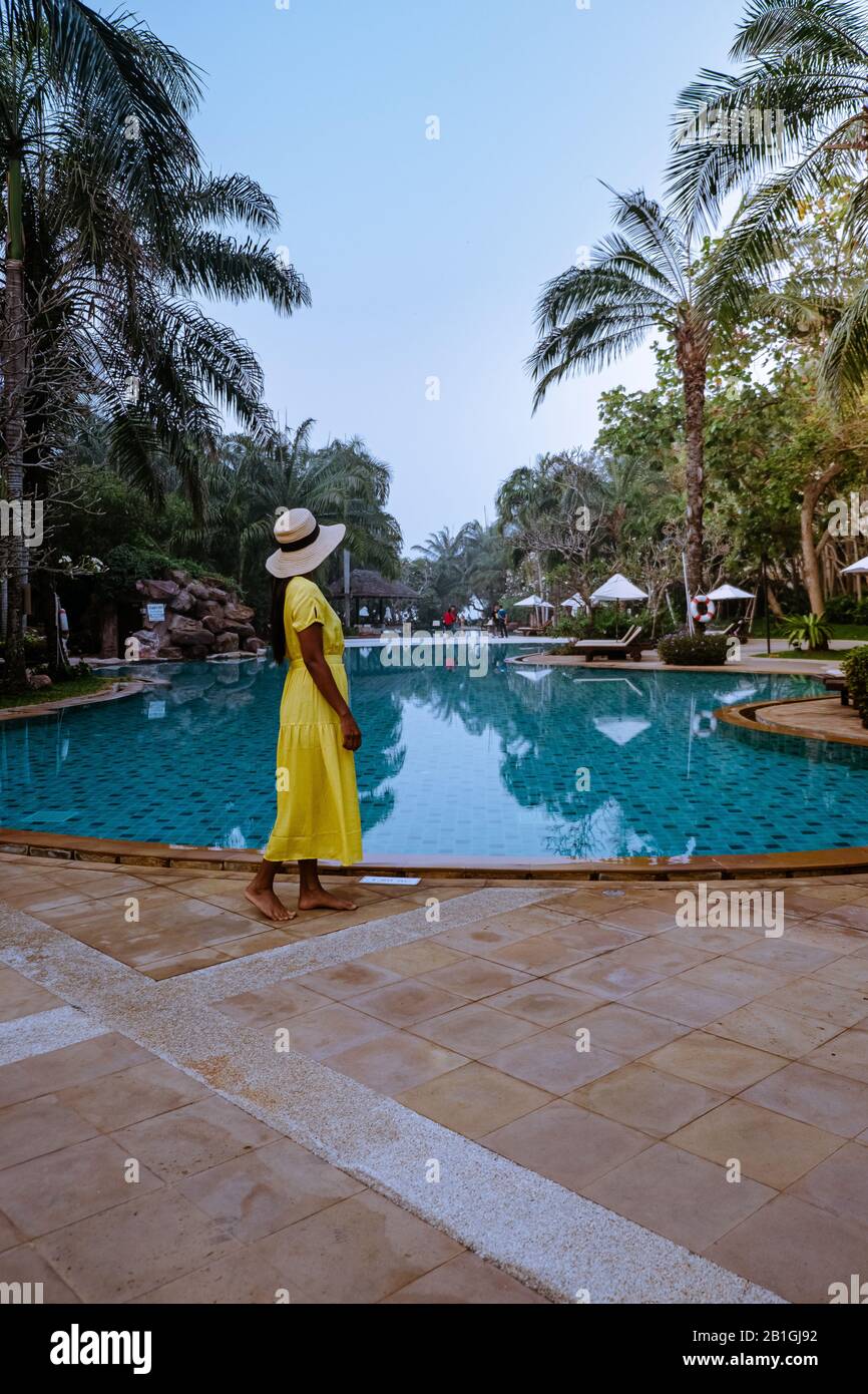 Ein Paar am Pool während der Bleichstunde bei Sonnenaufgang während des Urlaubs in Thailand Stockfoto