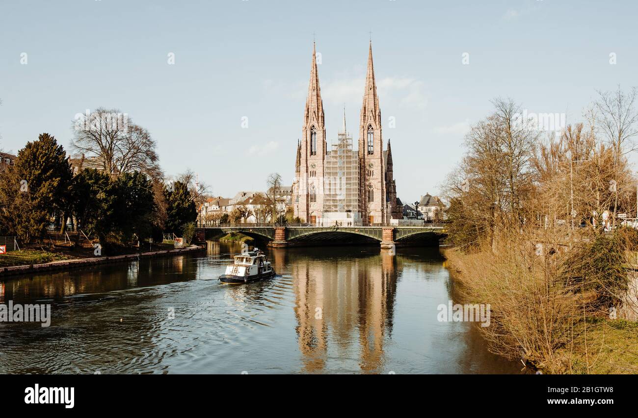 Strasbourg, Frankreich - 16. März 2014: Umbau der St. Paul's Church das bedeutende Gebäude der Gotik Revival-Architektur und eines der Wahrzeichen der Stadt Straßburg - Batorama Touristenboot auf Dem Fluss Ill Stockfoto