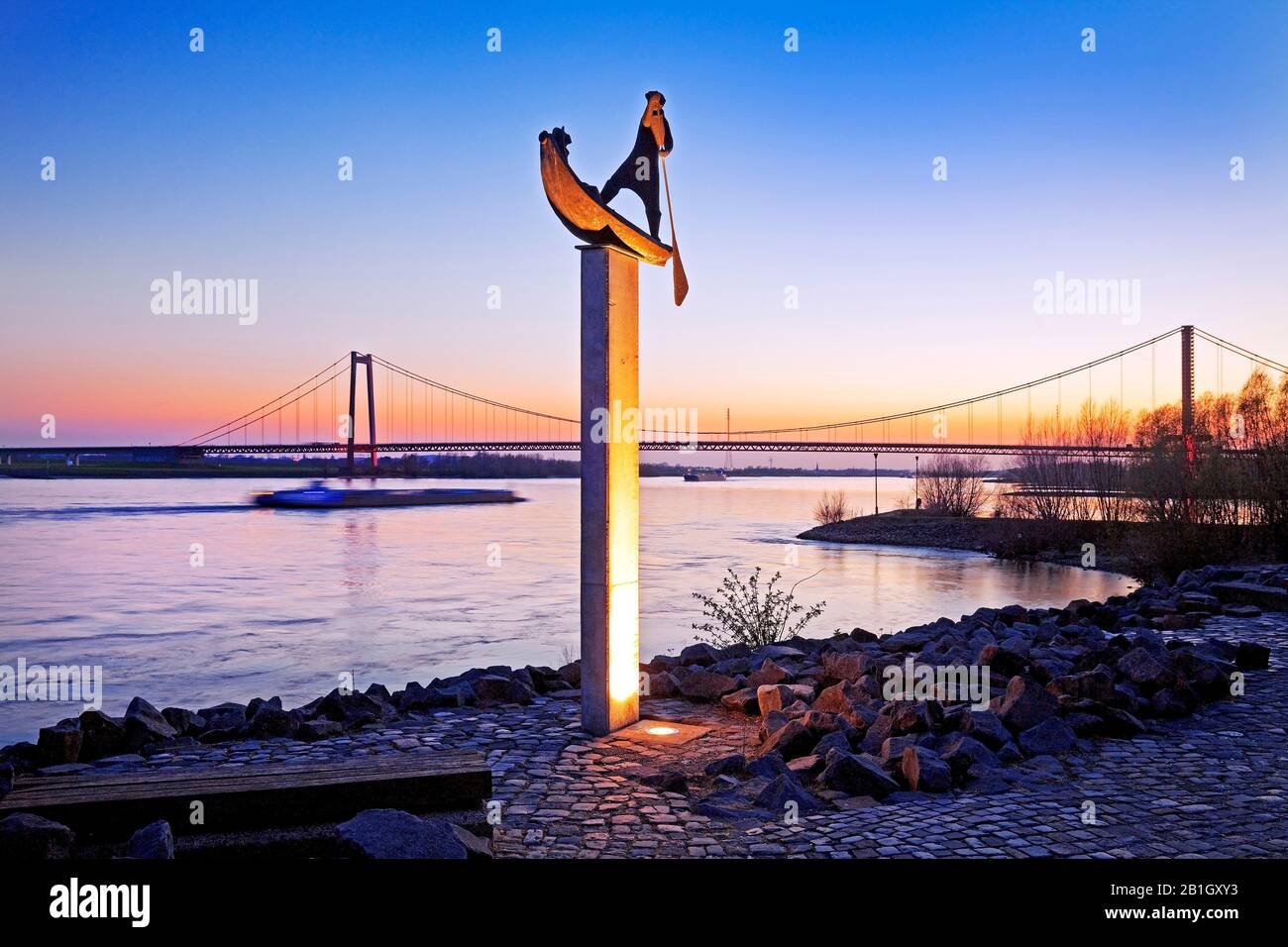 Illuminierter skulpturierter Fährmann am Rheinufer in Abendlicht, Deutschland, Nordrhein-Westfalen, Niederrhein, Emmerich Stockfoto