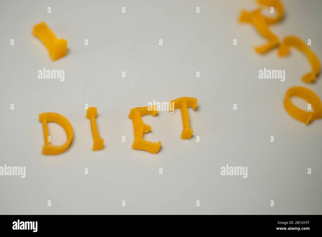 WORTDIÄT besteht aus essbaren Buchstaben. Nudeldiät Lebensmittel. Pasta in Form von Buchstaben auf grauem Hintergrund. Richtiges Ernährungskonzept. Kopierbereich Stockfoto