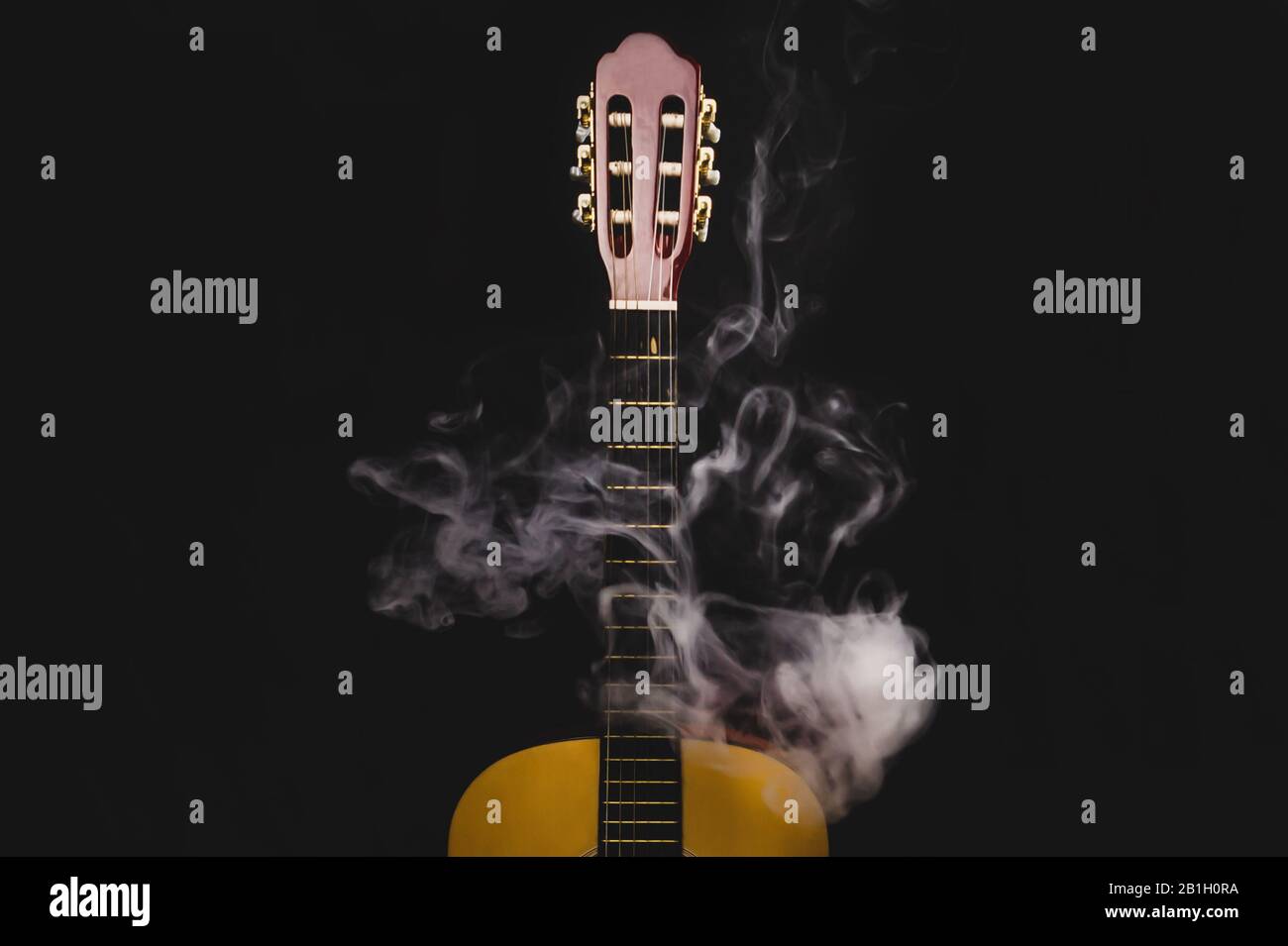 Gitarre im Rauch auf schwarzem Hintergrund. Akustisches Musikinstrument. Saiten am Gitarrenhals Stockfoto
