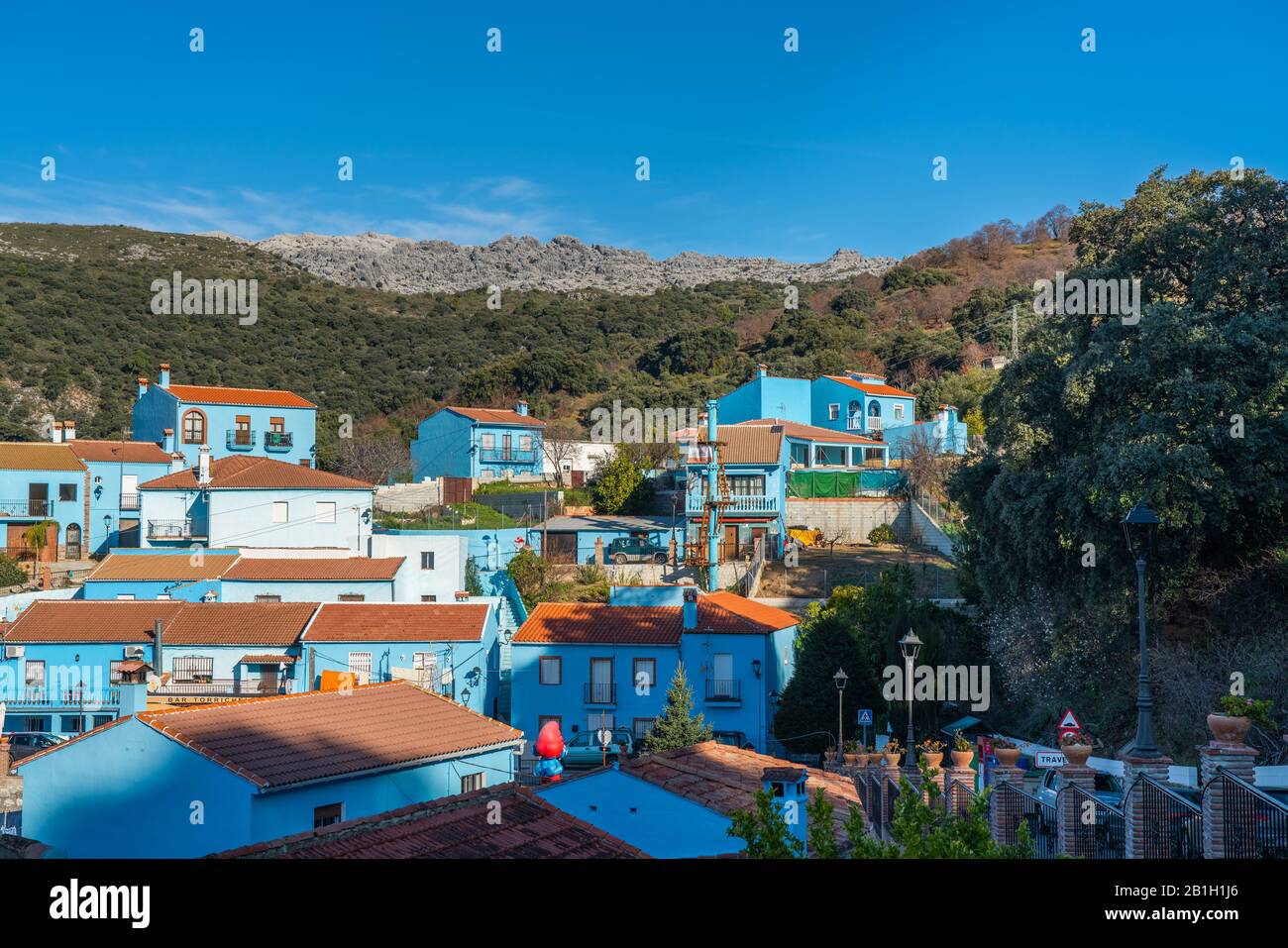 Juzcar, Spanien - 8. Januar 2020: Gebäude auf einem Hintergrund von Bergen in der blauen Stadt Juzcar, Provinz Málaga Stockfoto