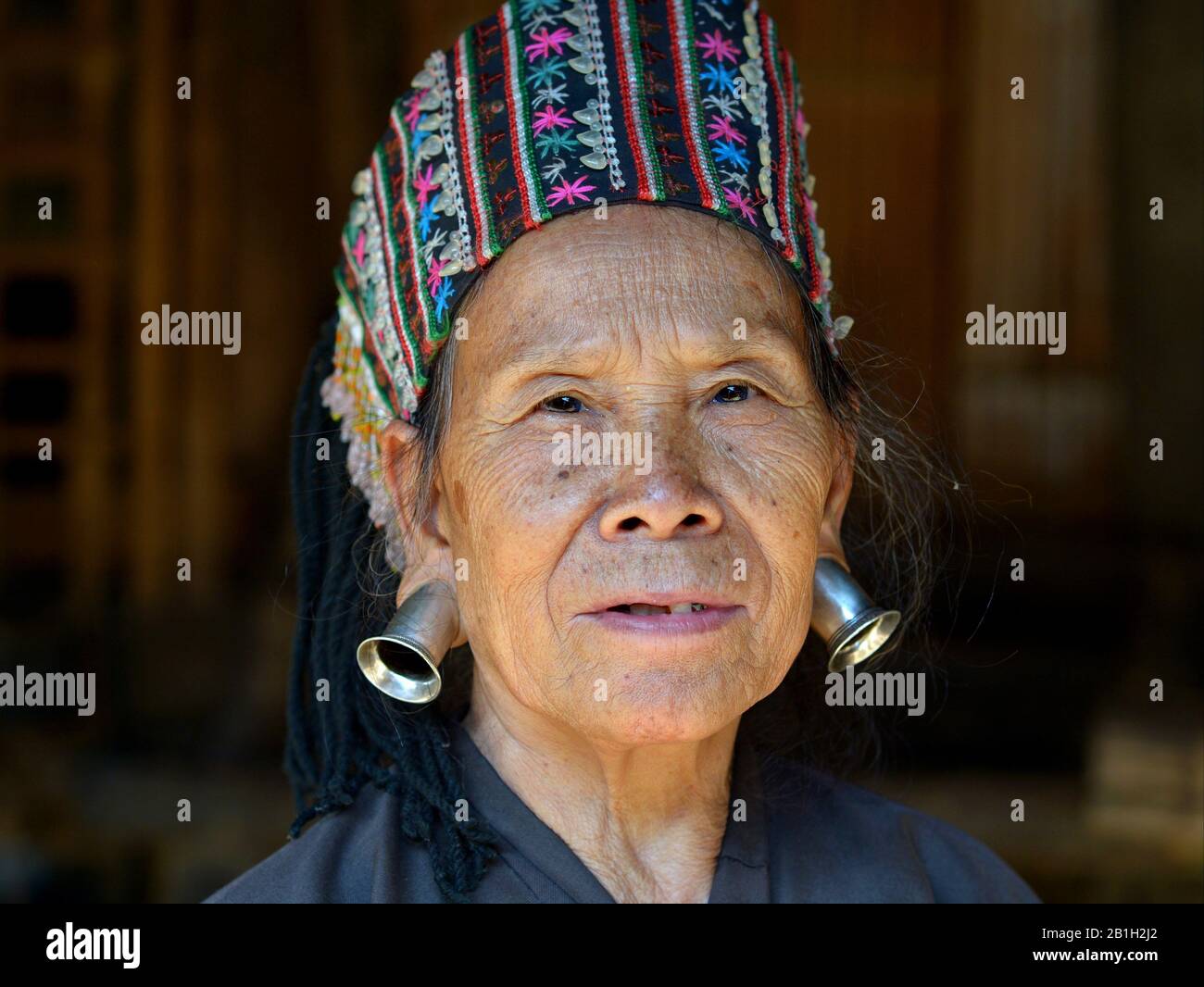 Ältere Thailänderin Lahu Shi Bala (Yellow Mu Sir) ethnische Minderheitsfrau mit großen Silber-Ohrenstöpseln aus Stammes für die Kamera. Stockfoto