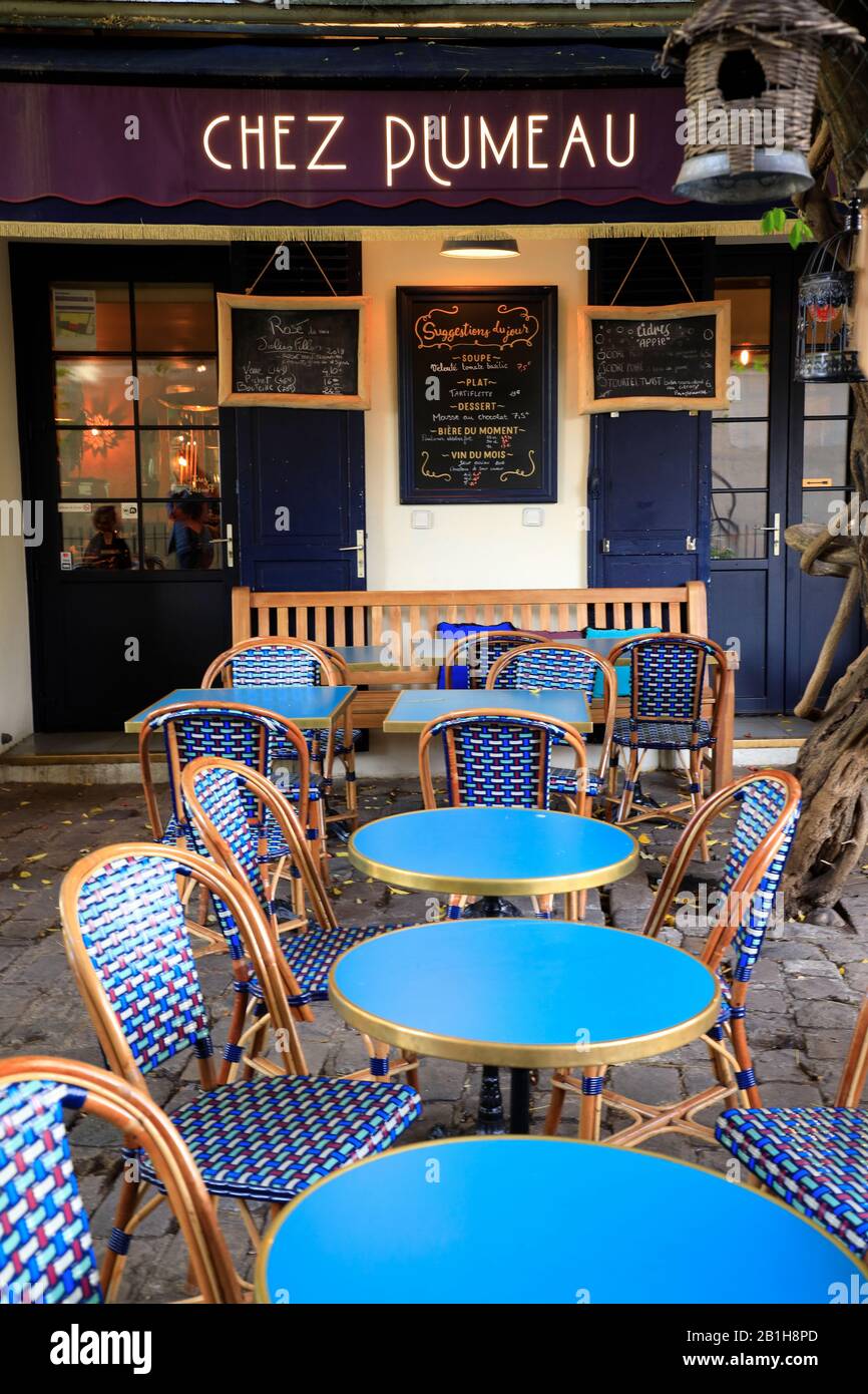 Blaue Stühle und Tische im typischen Pariser Café-Stil Die Sitzplätze im Freien im Restaurant Chez Plumeau.Montmartre.Paris.Frankreich Stockfoto