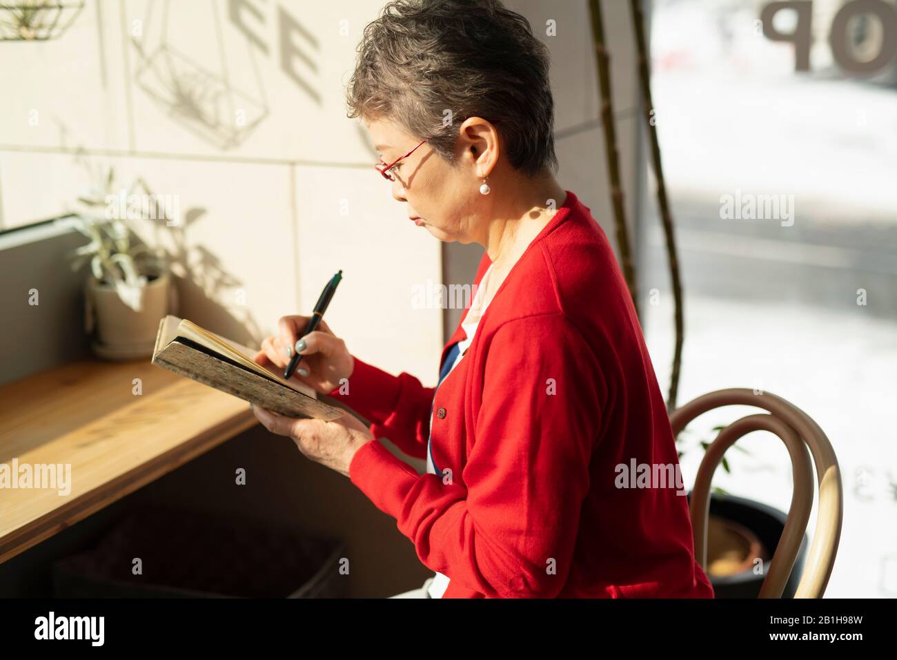 Seniorin nimmt Notiz Stockfoto