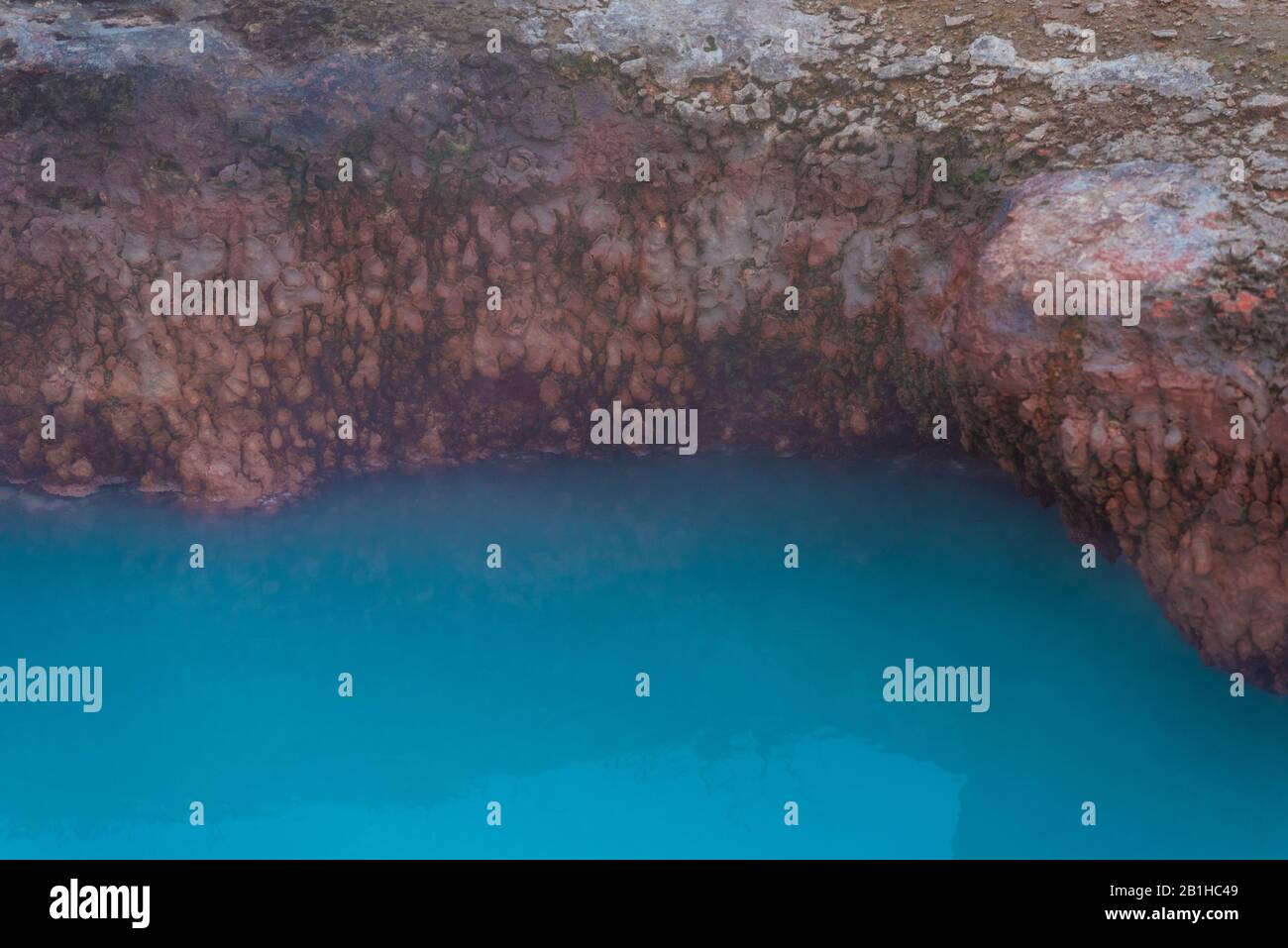 Friedliche, noch leuchtend blaue heiße Quelle. Stockfoto