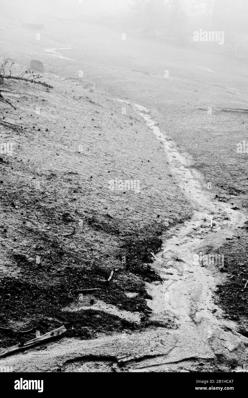 Strom von Wasser durch neblige fremde Landschaft. Stockfoto