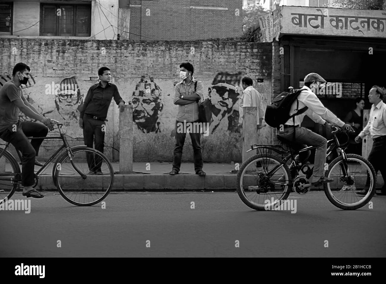 Menschen auf einem Straßenweg, in einem Vorfeld von städtischen Pendlern, die Fahrrad fahren in Kathmandu, Nepal, ein Jahr nach den Erdbeben von 2015. Stockfoto