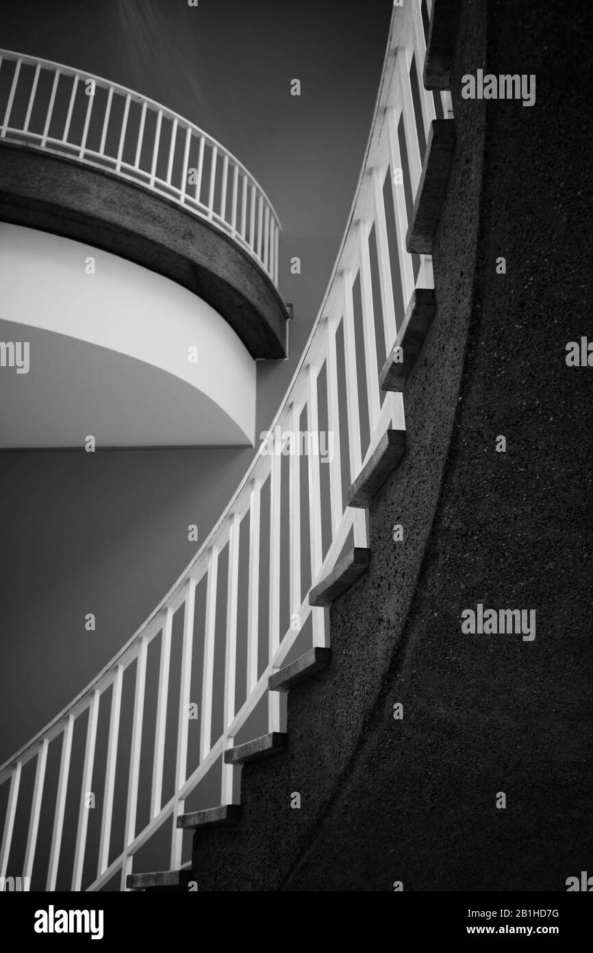 Treppe und Balkon von unten. Die Treppe führt von links nach rechts nach oben Stockfoto