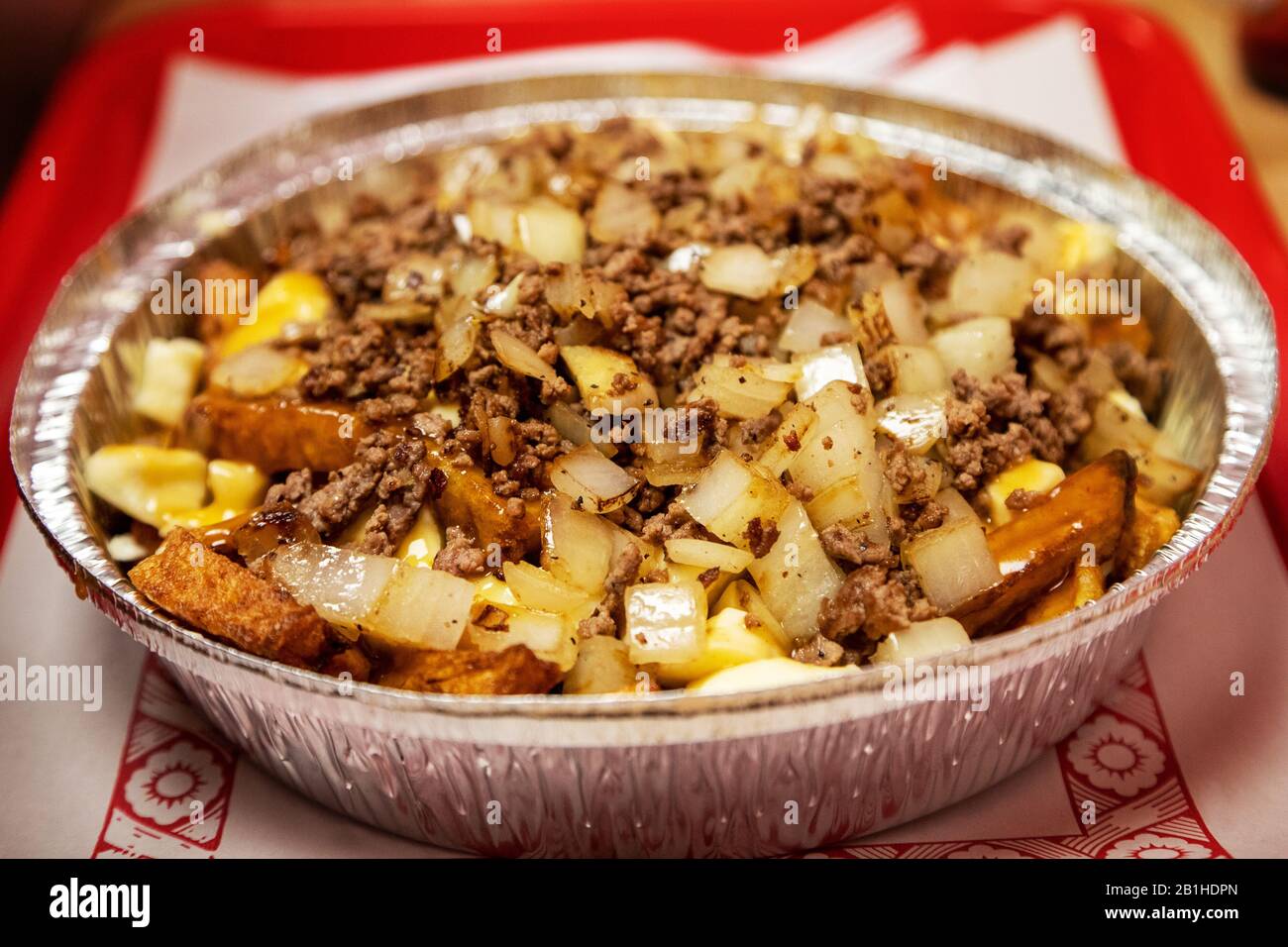 Berühmte kanadische Küche, bekannt als Poutine mit handgeschnittenen Pommes frites und Käsegewalten, die mit Zwiebeln, gemahlenem Rindfleisch und brauner Gravy bestockt sind. Das Gericht Stockfoto