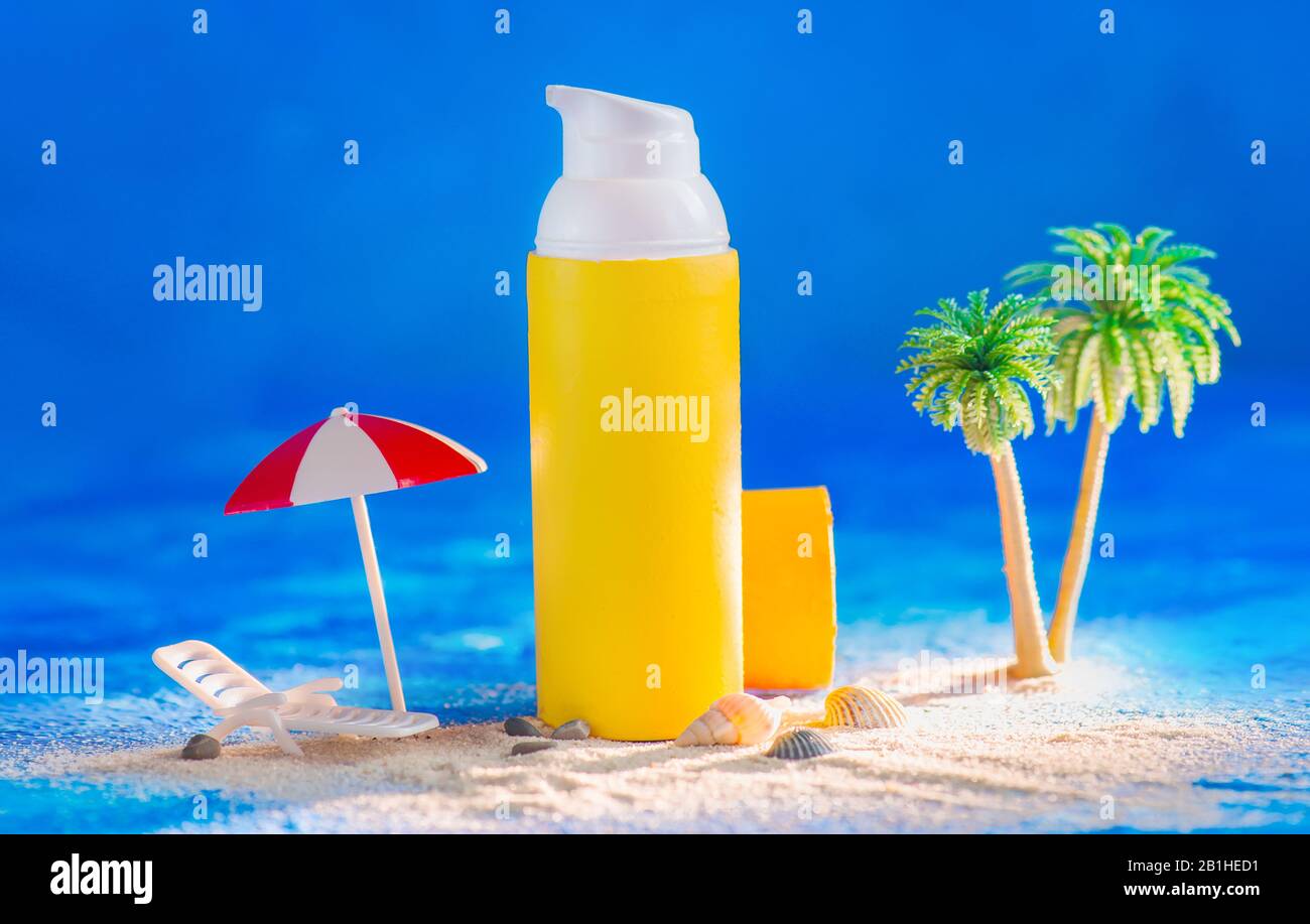 Sommer-Skinkare-Kopfzeile mit gelber Creme-Röhre mit Miniaturpalmen, Regenschirm und Liegestuhl an einem Strand Stockfoto