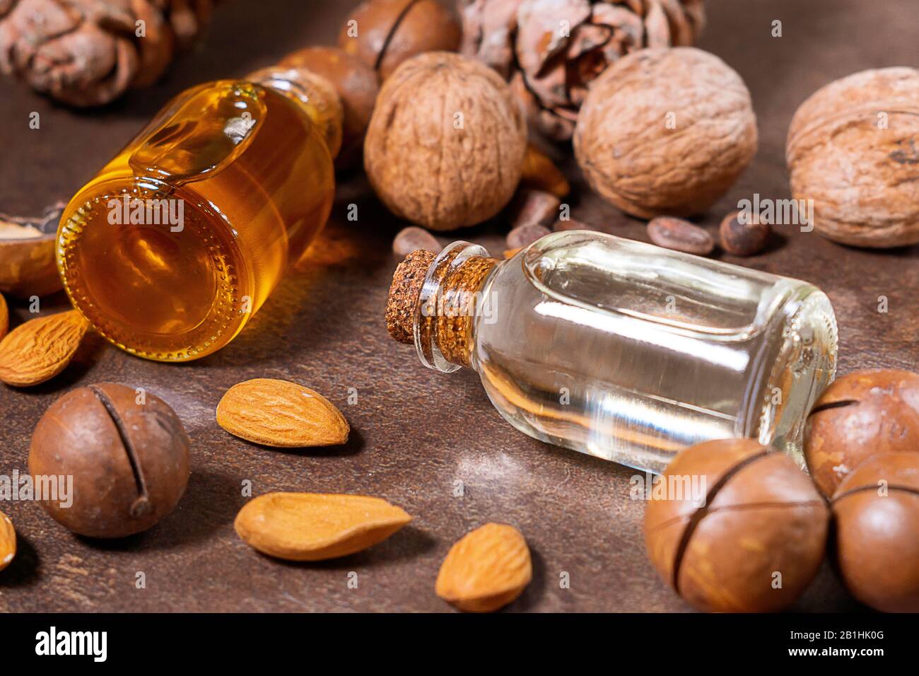 Flasche Aromaöl, Nüsse, Mandeln, Walnüsse, Macadamia. Organische Kosmetikprodukte, selektiver Fokus. Spa, Massage, weibliche Behandlung, Aromatherapie-Körper Stockfoto