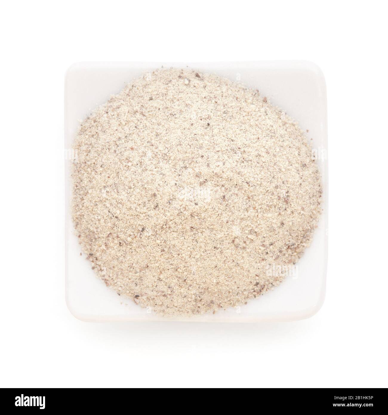 Weißer Pfeffer gemahlen in einer weißen Schüssel auf weißem Hintergrund. Wird weltweit als Gewürz in der Küche verwendet. Stockfoto