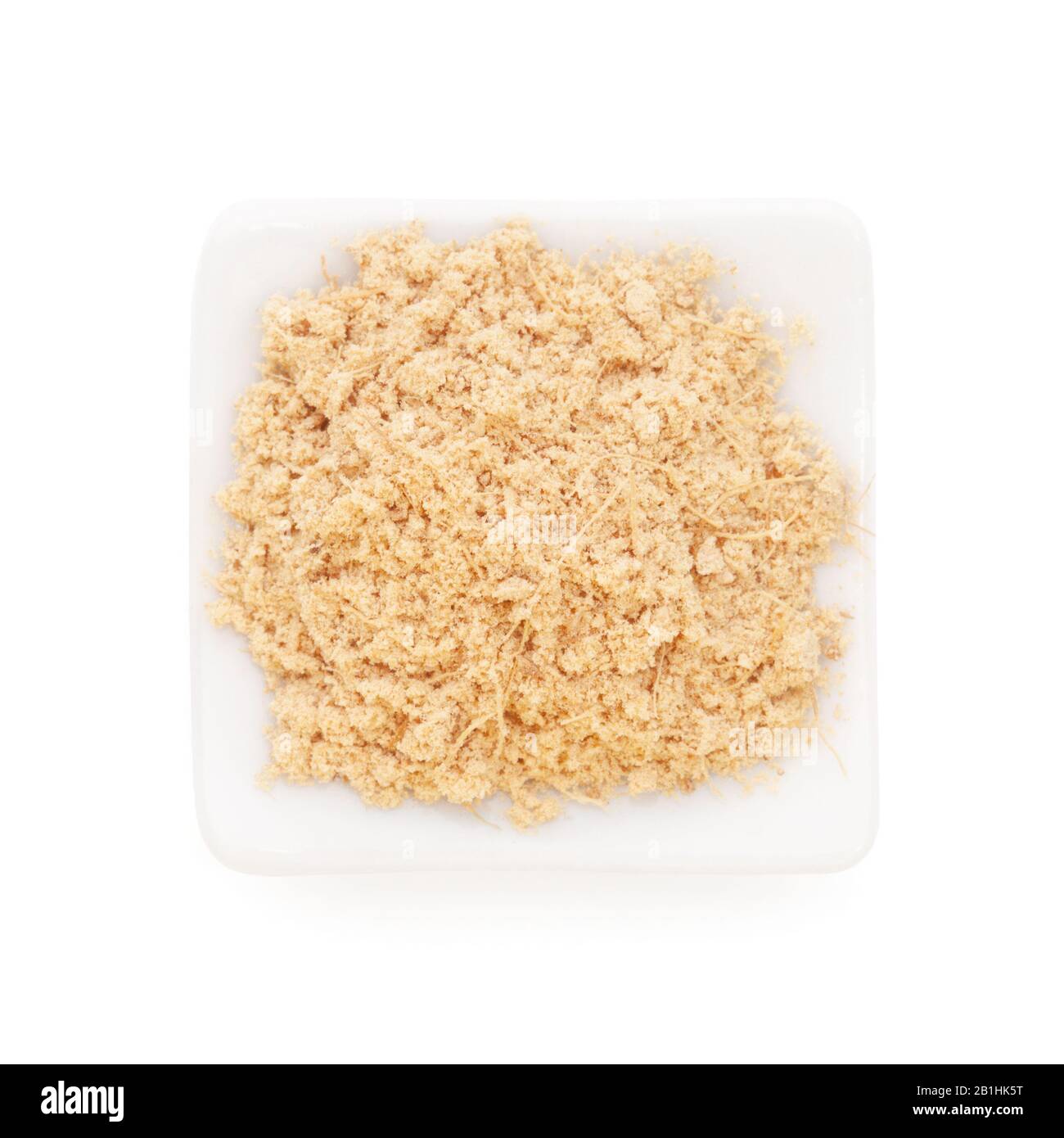 Gemahlener Ginger (Zingiber officinale) in einer weißen Schüssel auf weißem Grund. Wird weltweit als Delikatesse, Medizin oder Gewürz verwendet. Stockfoto