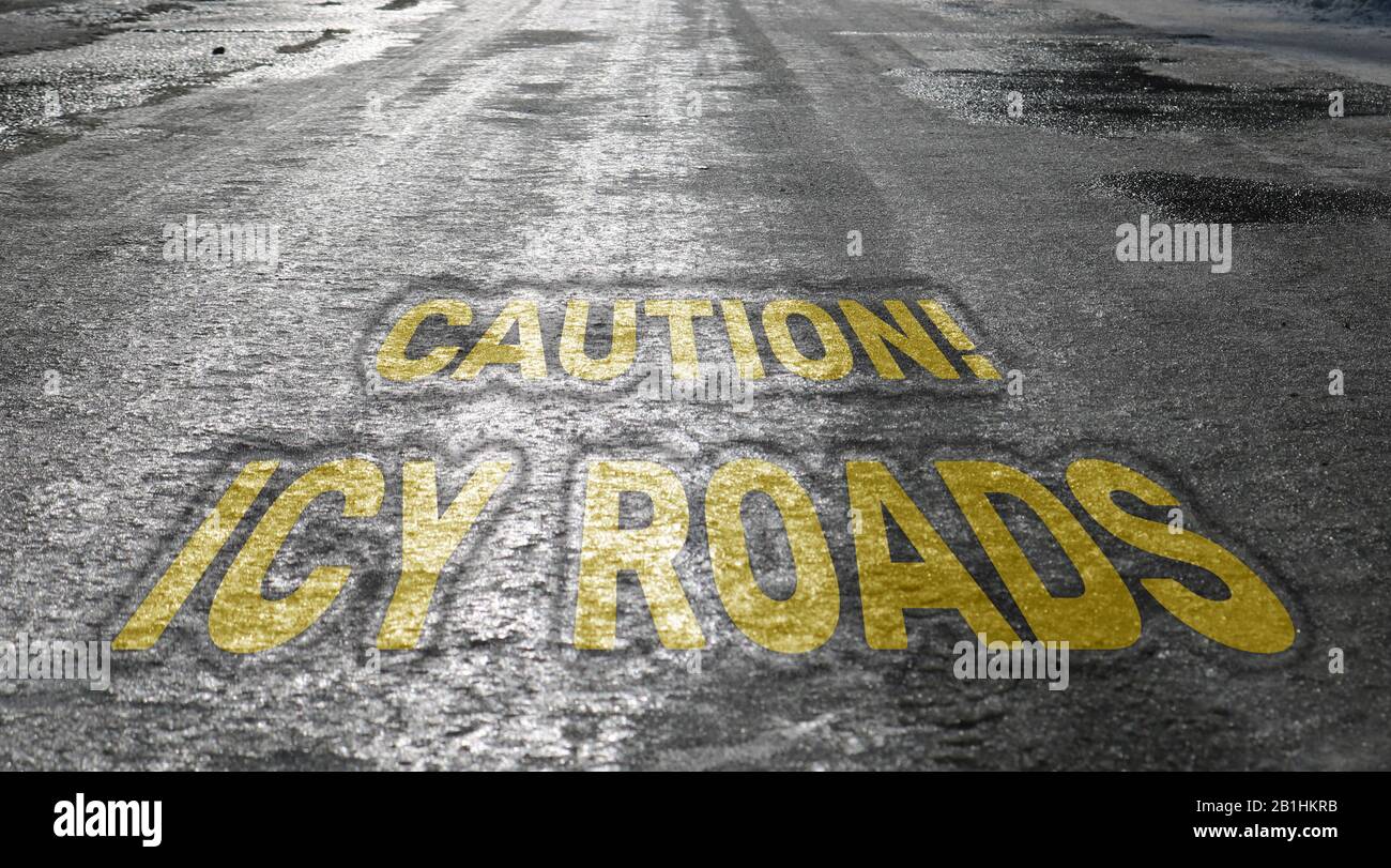 Eisige Straße. Selektiver Fokus. Gefahrenkonzept Eisverkrusteter Boden. Mit der Aufschrift "Achtung! Eisige Straßen' Stockfoto