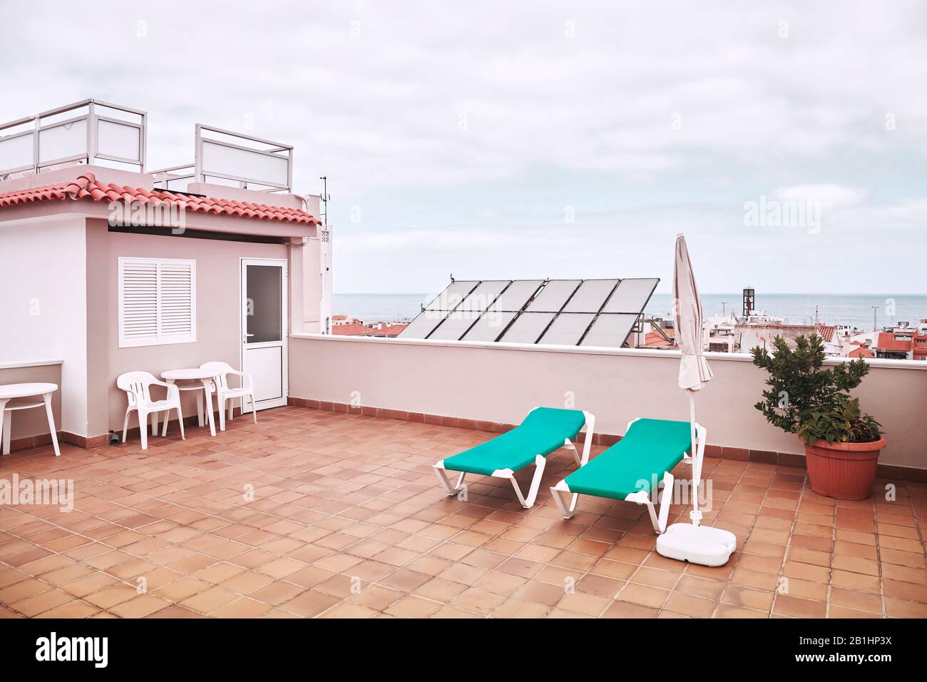 Dach mit Sonnenliegen an einem bewölkten Tag, farbenes Bild. Stockfoto