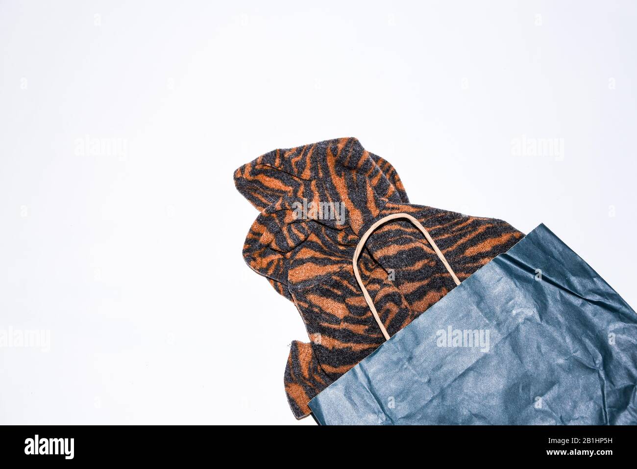 Pullover- und Papiertüte für Frauen auf hellem Hintergrund, Draufsicht. Kopierbereich, Stockfoto