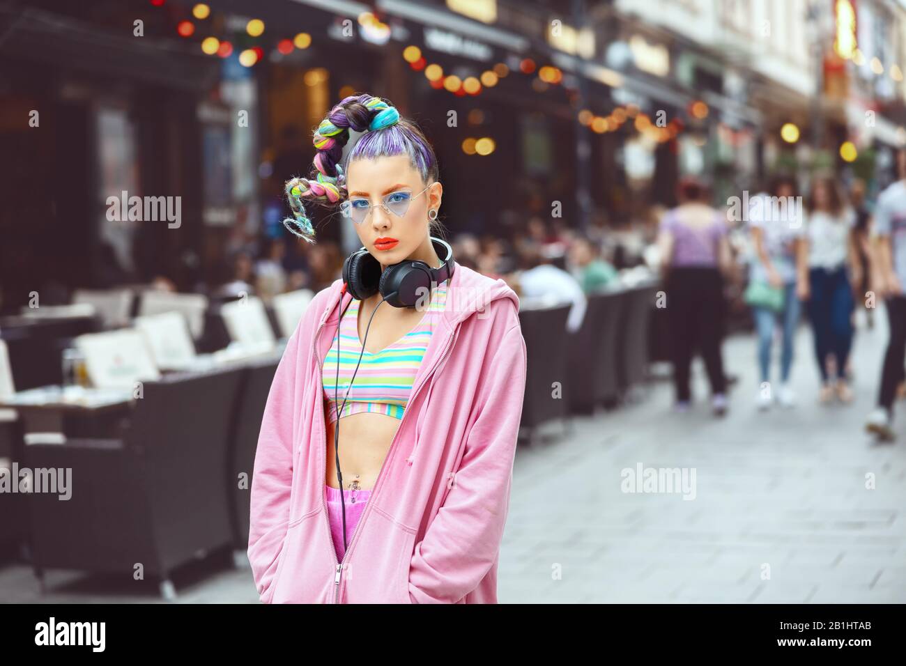 Funky Teenager-Mädchen mit avantgardistischen Modehaaren und Kleidung im Stil von Hipper Street in der City Street Stockfoto