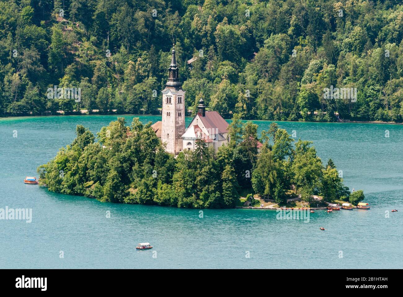 Blick auf die Bleder Insel am Bleder See in Slowenien, mit einem Kirchturm der Kirche, der Mariä Himmelfahrt gewidmet ist. Stockfoto