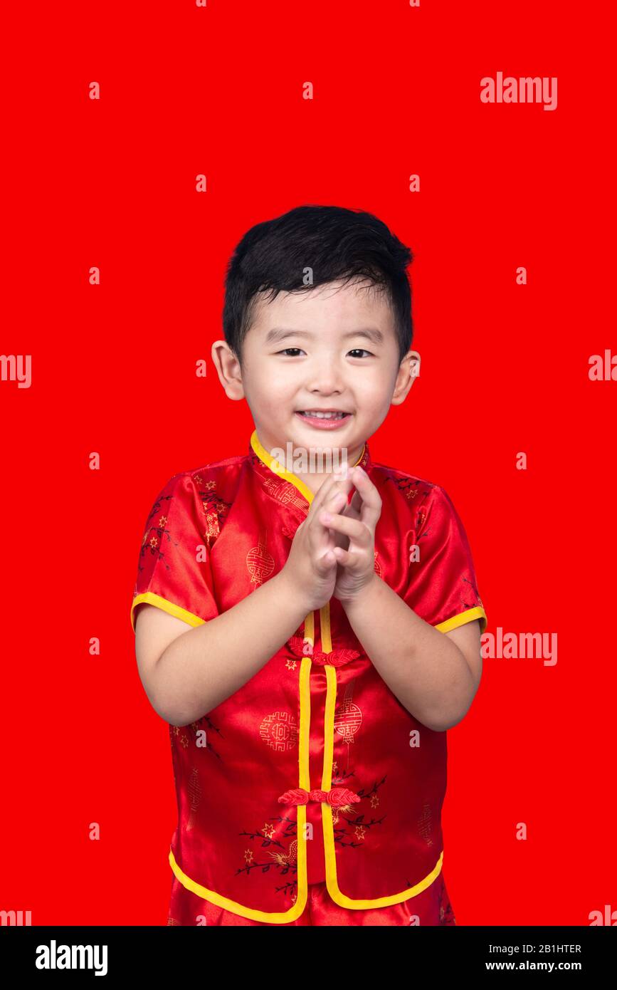Das chinesische Neujahr Konzept, Cute Asian Boy rot Traditionelle Chinesische Klage auf rotem Hintergrund mit Freistellungspfad isoliert. Stockfoto