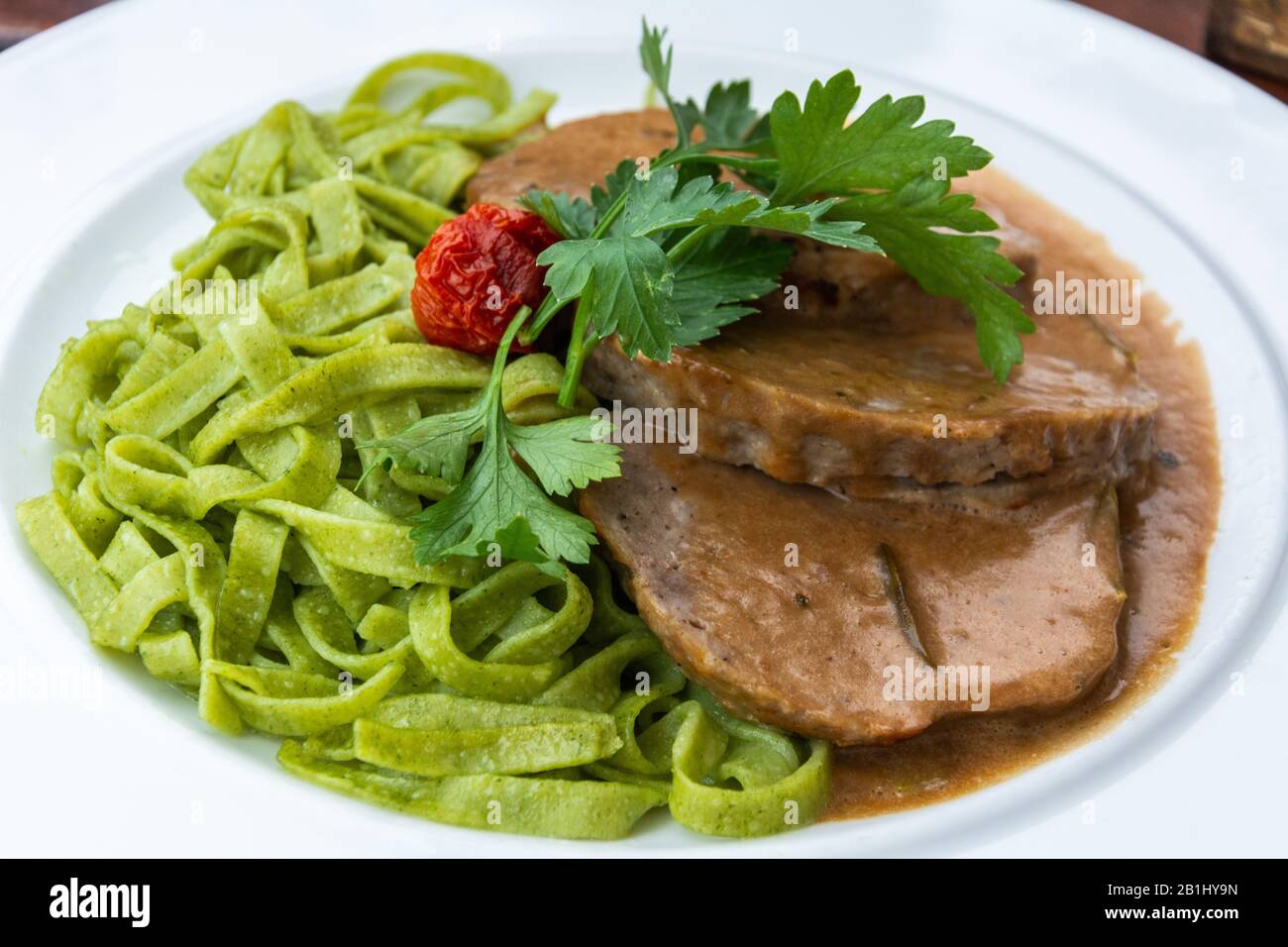 Gebratenes Hackfleisch auf Rosmarincreamsauce mit Spinatnudeln in der ...