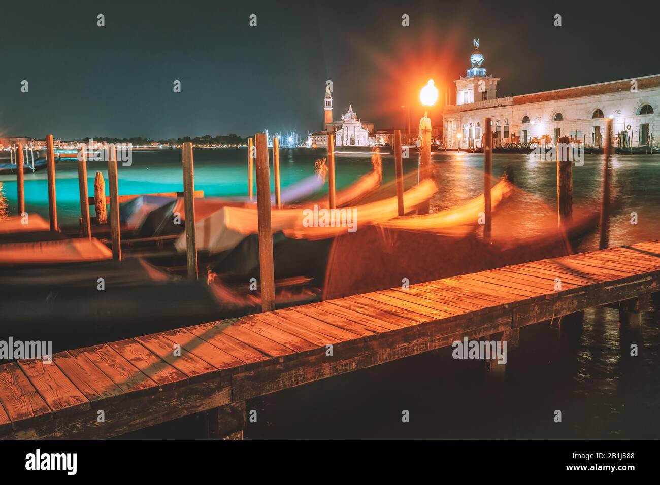 Venedig Nachtlandschaft vom Stadtkanal mit am Canal Grande verankerten Gondeln - lange Belichtungszeit mit verschwommenen Gondeln Stockfoto