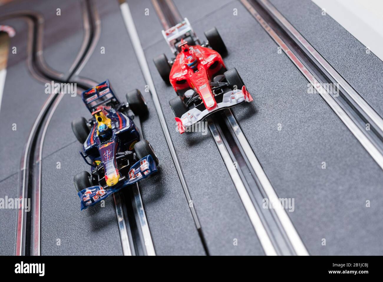 Modell Formel 1 Redbull und ein Ferrari Style Slot Cars, die auf einer Scalextric-Strecke Rennen Stockfoto