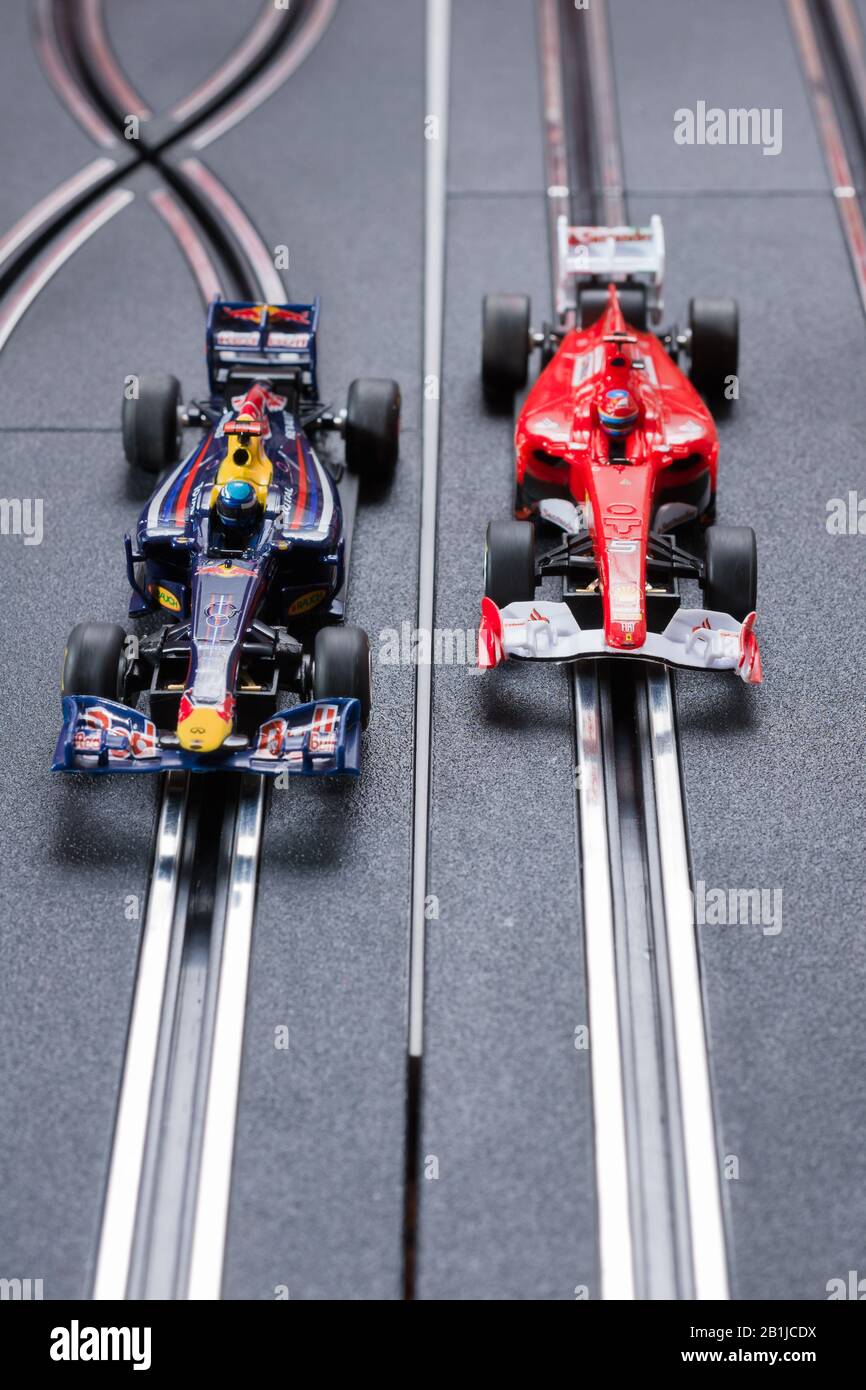 Modell Formel 1 Redbull und ein Ferrari Style Slot Cars, die auf einer Scalextric-Strecke Rennen Stockfoto