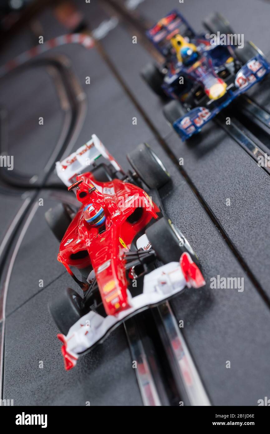 Modellformel eins Ferrari- und Redbull-Slot-Autos, die auf einer Scalextric-Strecke Rennen Stockfoto