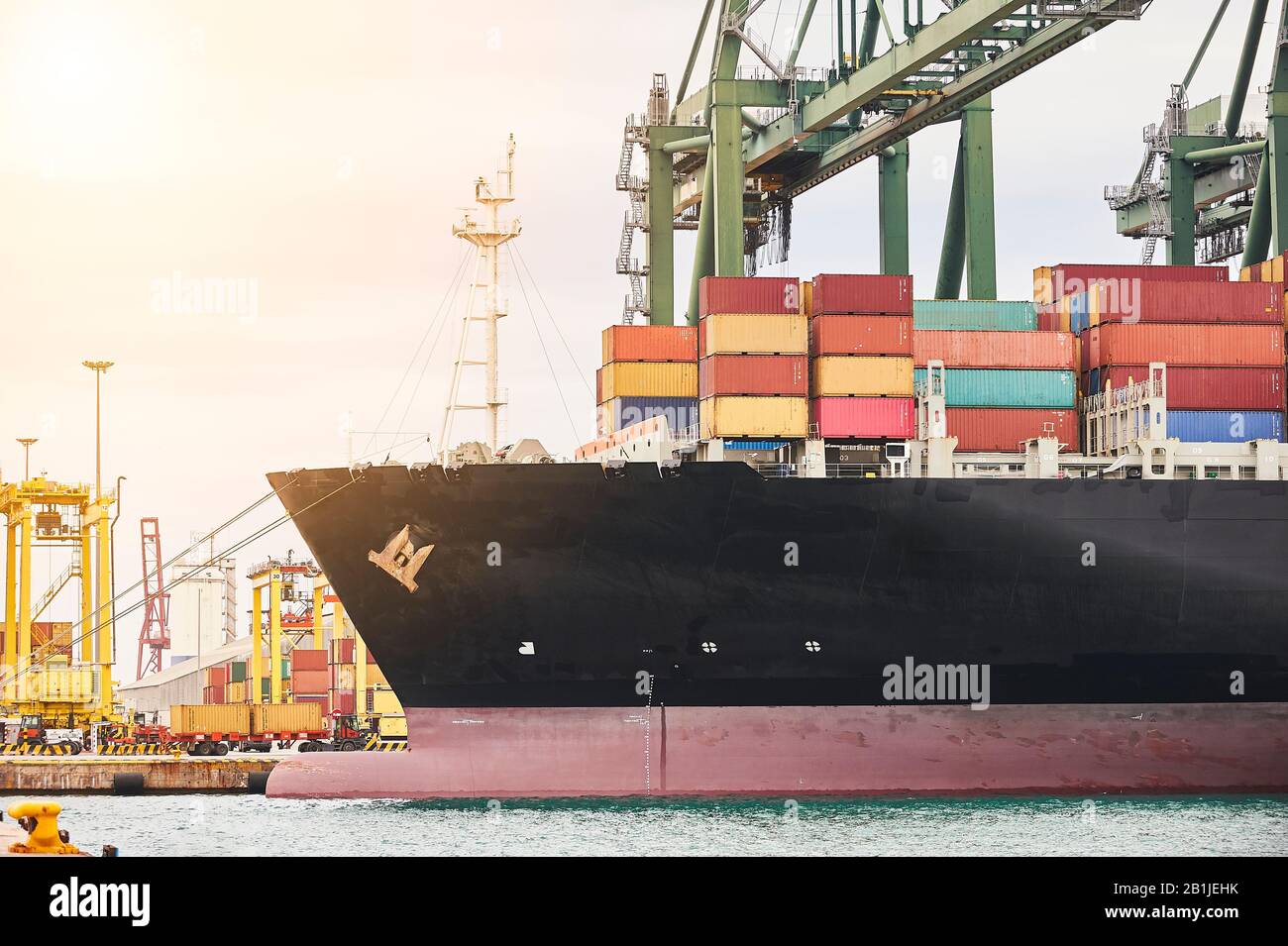 Container werden im Hafengebiet transportiert. Transportindustrie und Versandlogistik. Exportieren und Importieren von Bussinen. Frachter im Hafen festgemacht Stockfoto